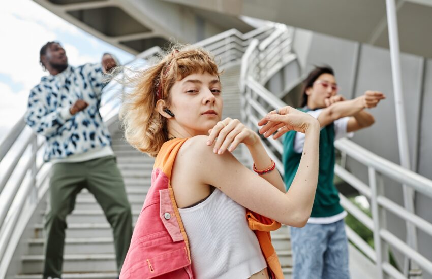 Diverse group of people dancing outdoors in urban city setting