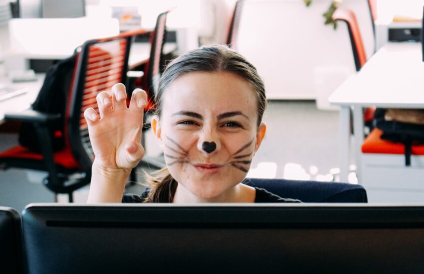 Woman at the office masked as a cat for Halloween. Fun at the office